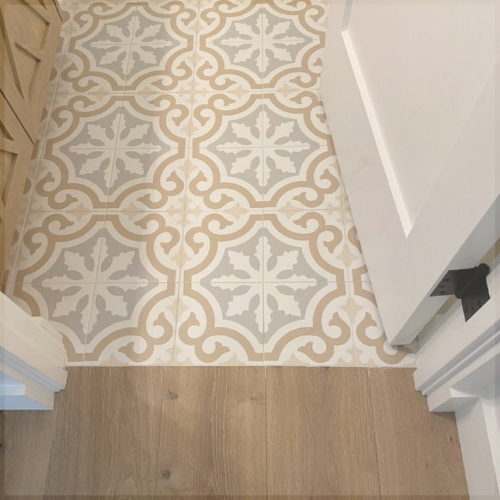 Carrelage à motifs géométriques beige et blanc posé dans une entrée, illustrant l’importance du sens de pose pour guider le regard et dynamiser un intérieur.