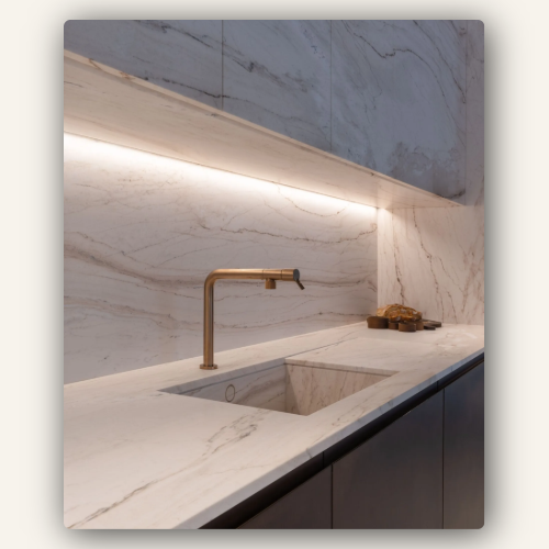 Cuisine design avec crédence et plan de travail en marbre blanc éclairé par LED