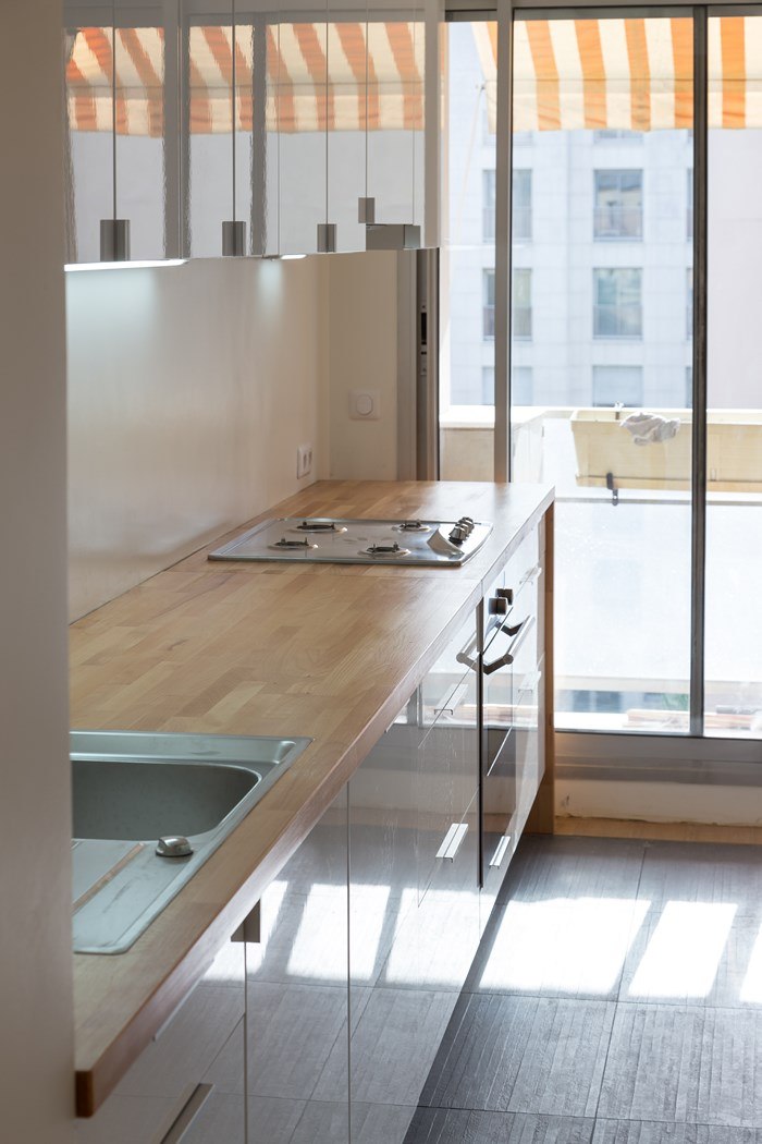 Appartement Levallois, cuisine au plan de travail bois ouverte sur le balcon